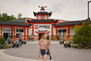 girl stands in front of LEGO Ninjago: the ride entrance, one of the main attractions featuring interactive elements at legoland New York resort