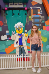 girl stands in front of dr. brick (a minifigure themed to a scientist), one of the several character meet and greets available at legoland New York resort