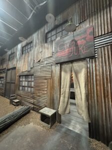 Corrugated metal building exterior with a hand-painted 'Club Juke' sign, part of the Sinners set