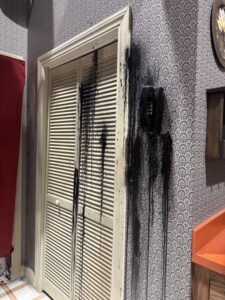 Black substance dripping down a closet door and wall phone in a Stranger Things 5 haunted house scene